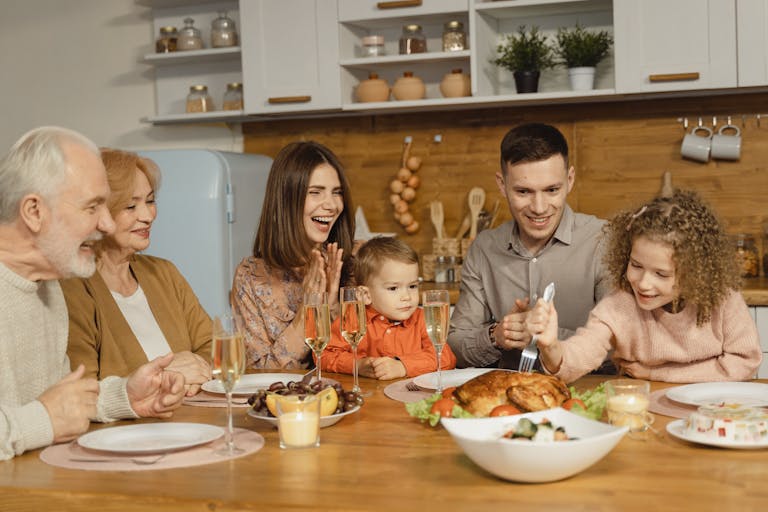 generation build wealth A joyful family gathering around a table for a Thanksgiving feast indoors.