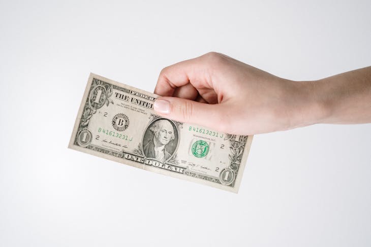 generation Close-up of a hand holding a one US dollar bill against a white background. Ideal for finance-related themes.