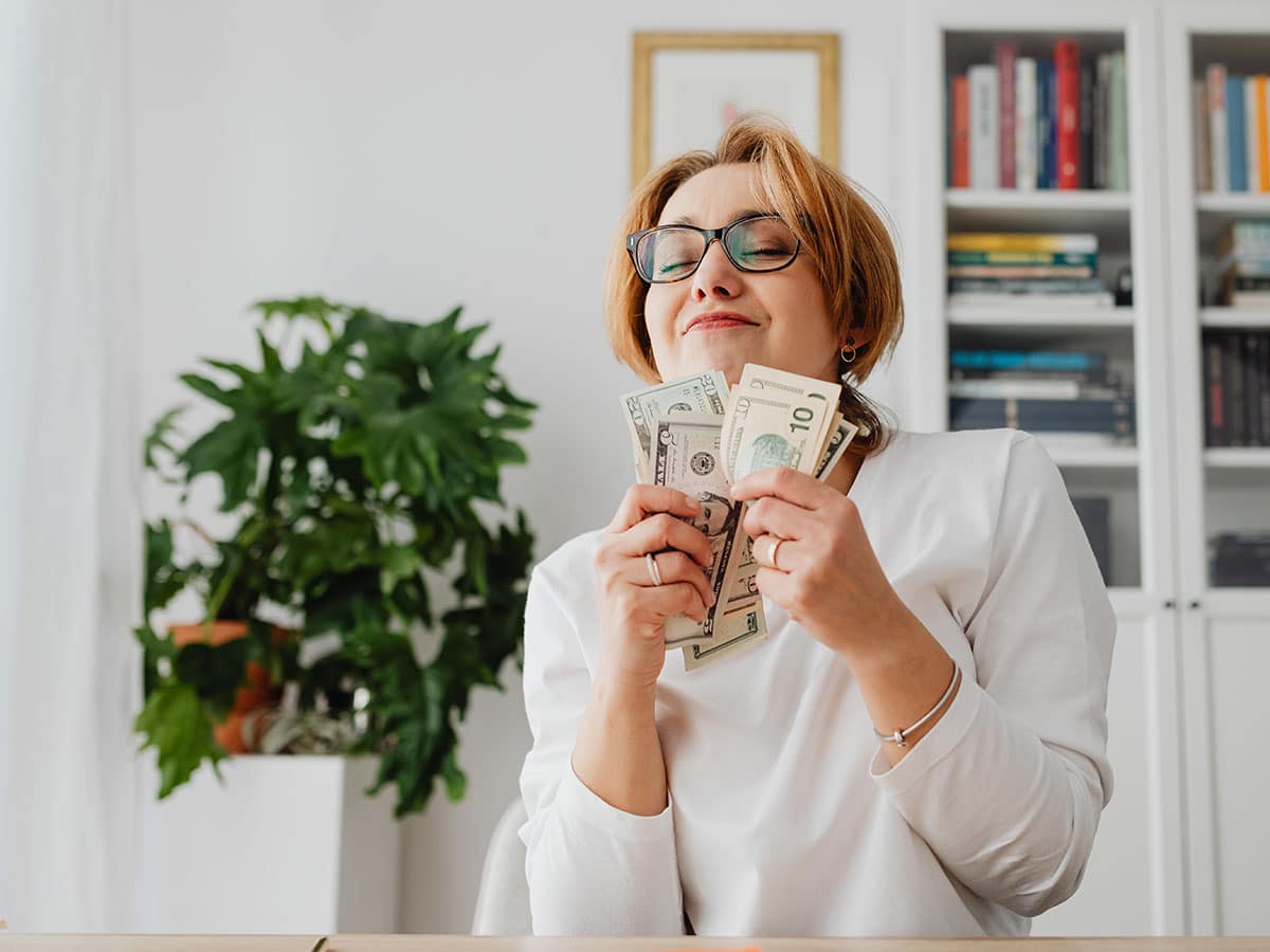 Woman saving money with the 52 week savings challenge.