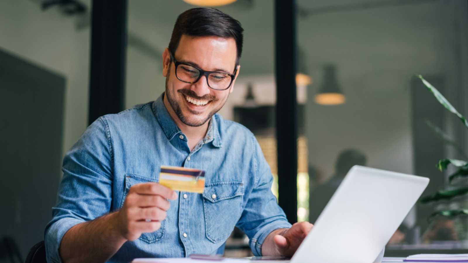 Happy man using credit card.