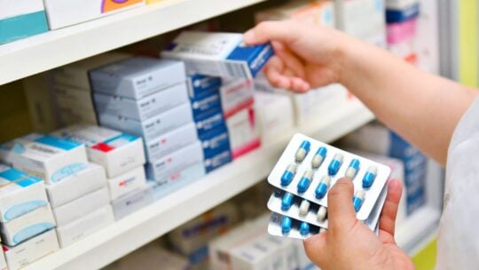 Pharmacist holding medicine box