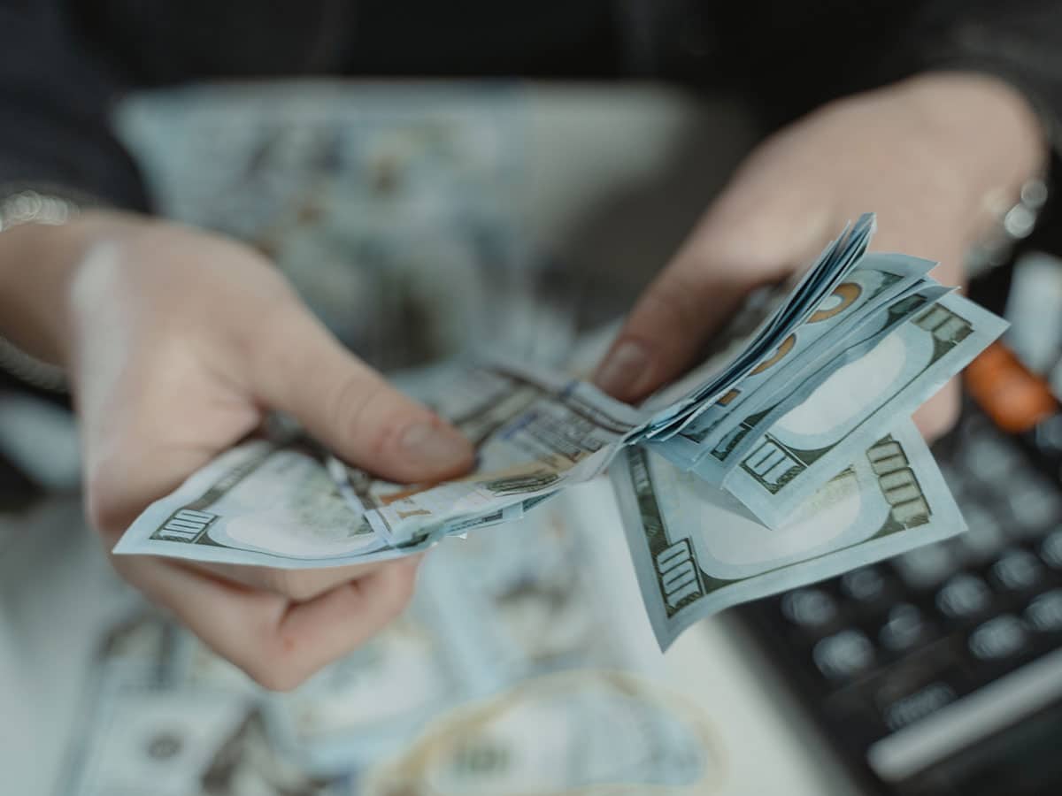 Person counting cash and wondering if their emergency fund is too big.