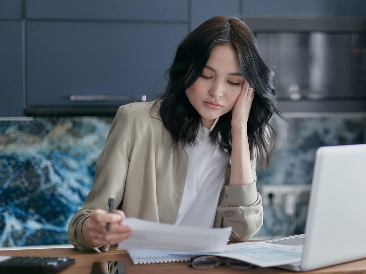 Woman staring nervously at a bill.