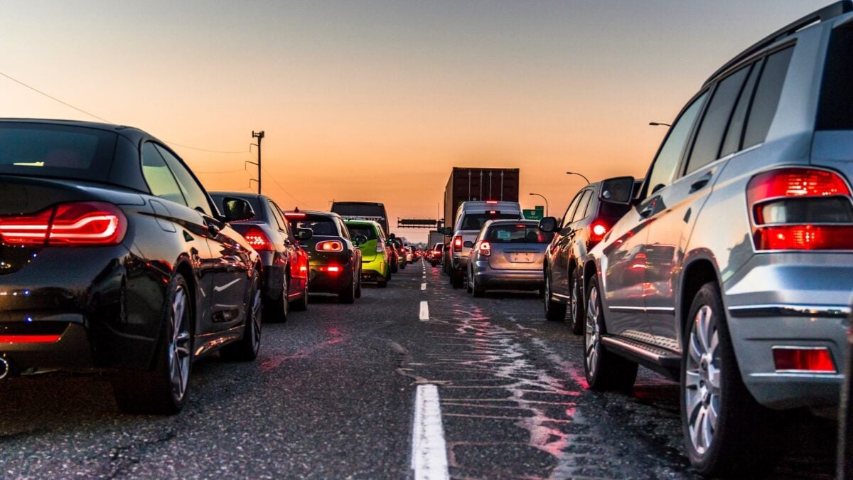 Traffic jam on a busy highway at rush hour. Cars in line, bumper to bumper, stuck in traffic at dusk on a clear sky night.