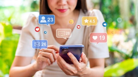 Young woman using mobile phone with Social media interactions and notification icons while traveling for summer vacation