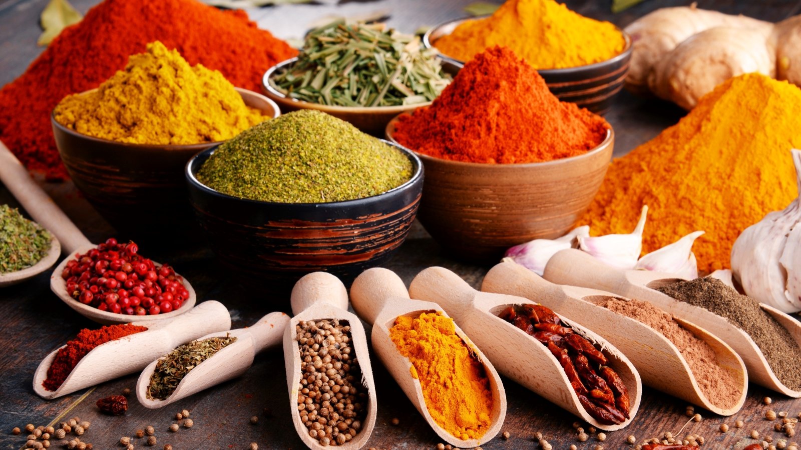 Variety of spices and herbs on kitchen table.